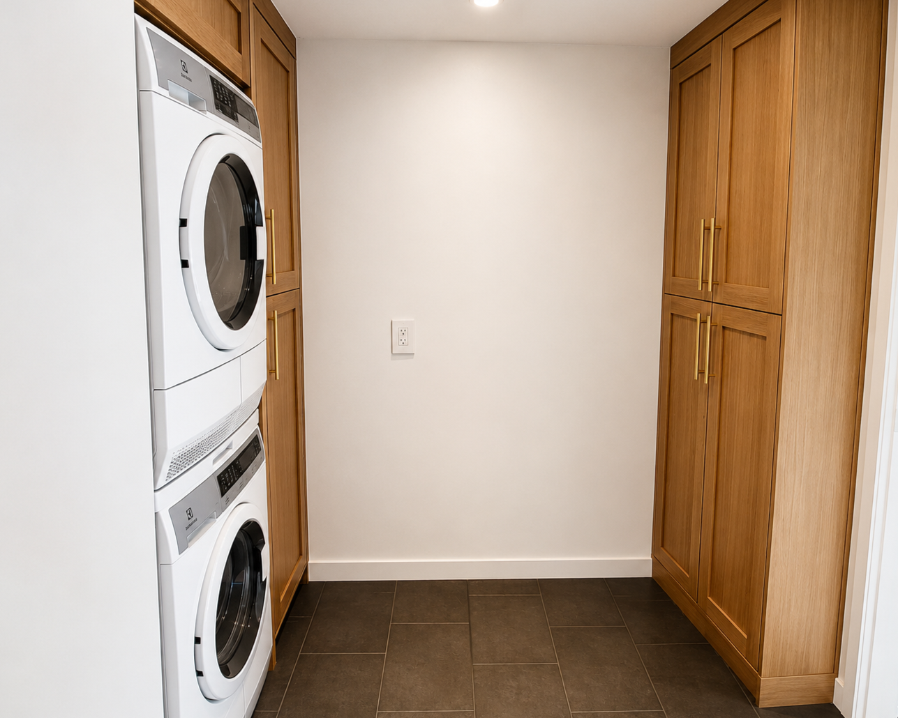 Custom laundry room renovation with stacked washer dryer and built-in cabinetry in Portland.