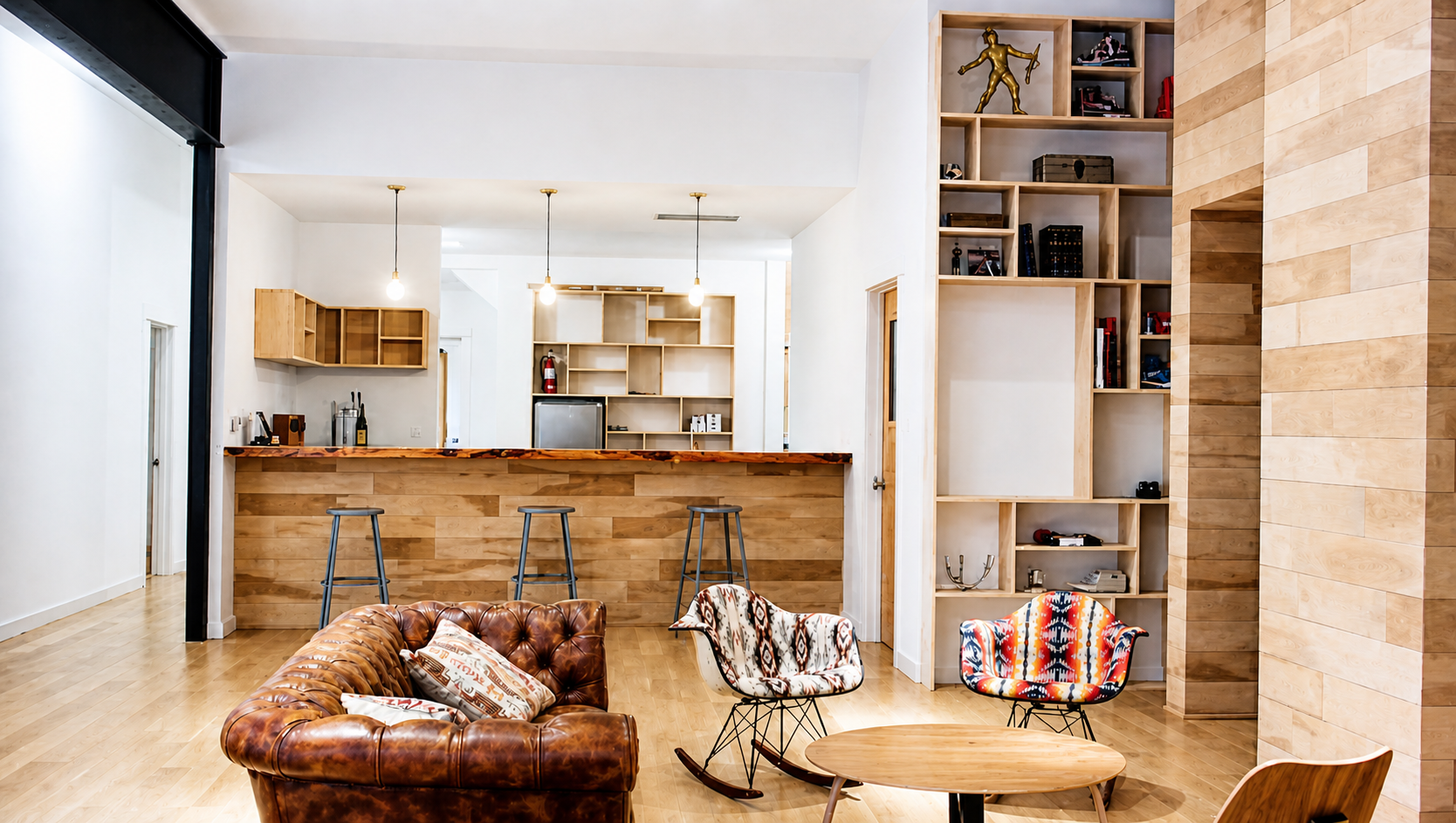 Bright modern living room with open kitchen and built-in shelving by Rip City Construction