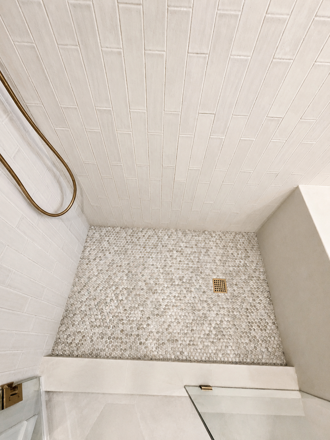 Custom walk-in shower featuring penny tile flooring, linear layout, and premium tile installation in a Northeast Portland bathroom remodel.