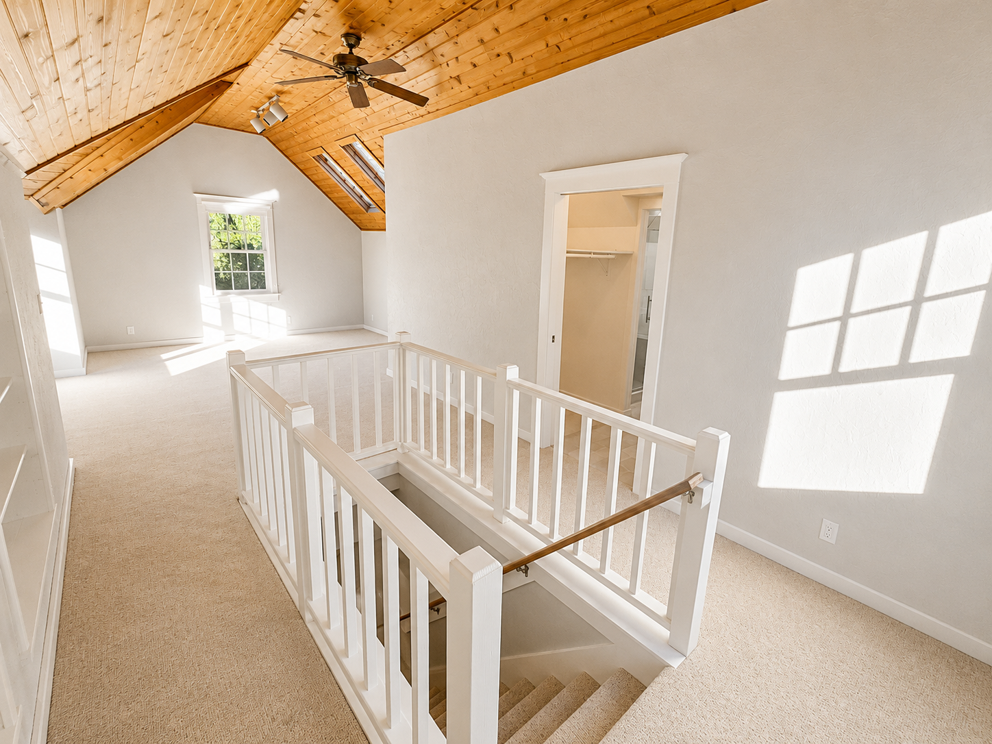 Updated primary bedroom with custom railings, vaulted ceilings, built-in storage, and bright modern finishes in Northeast Portland.